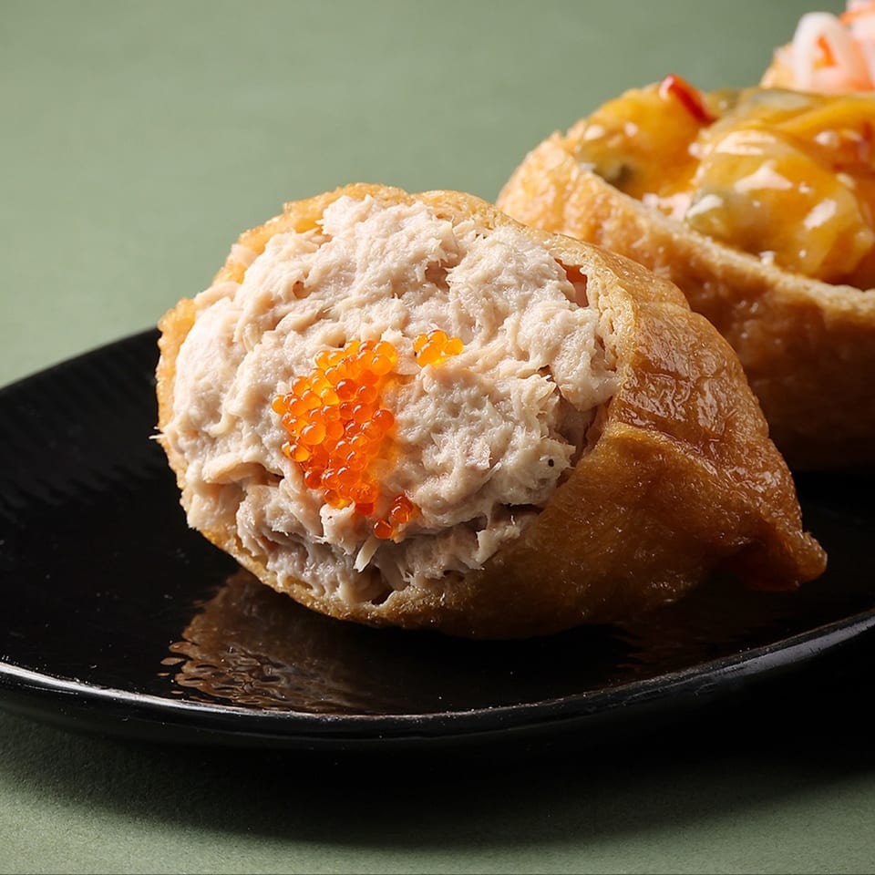 Close-up of Bloop Bloop's sushi, featuring a fried tofu pocket filled with tuna salad and orange roe.
