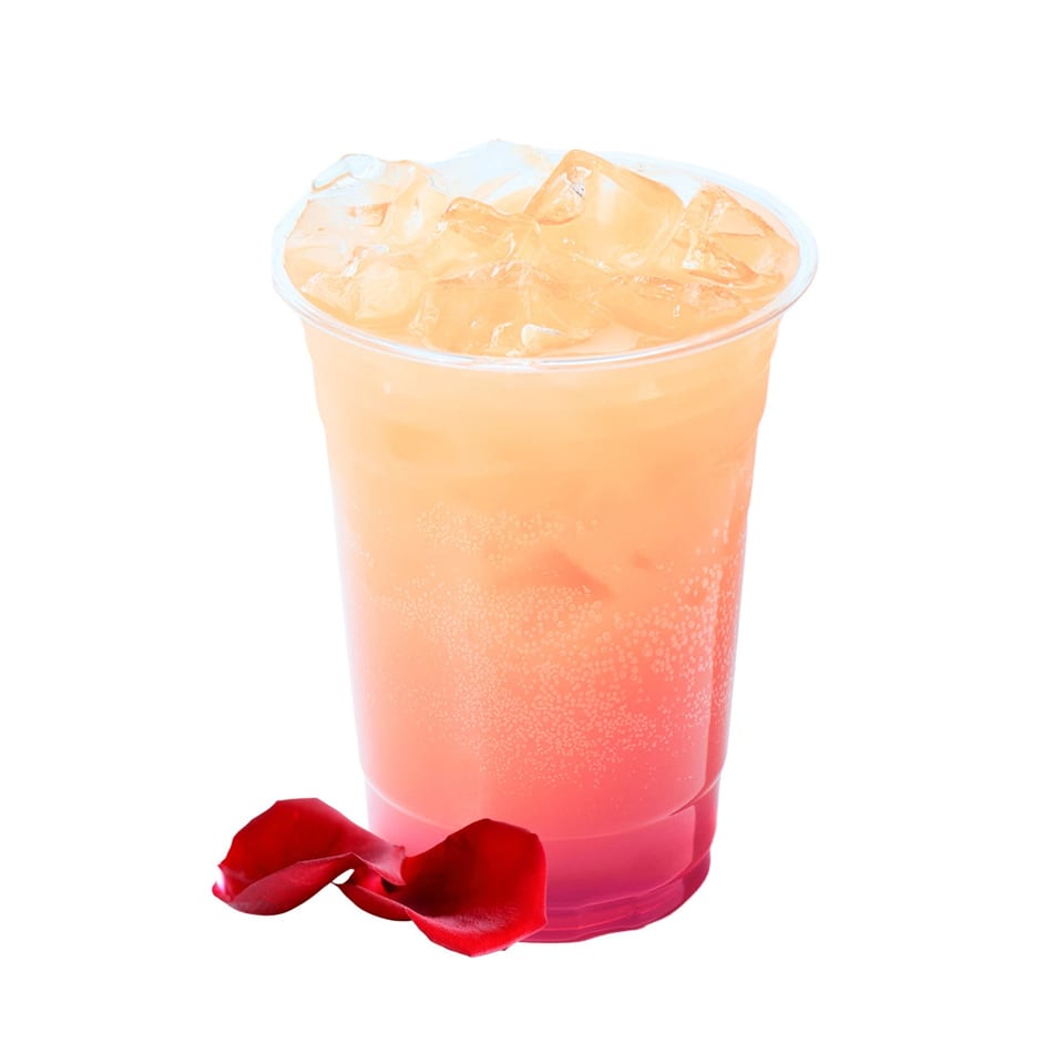 Bloop Bloop's iced rose-colored drink in a clear cup with red rose petals.